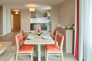 uma cozinha e sala de jantar com mesa e cadeiras em Zenao Appart'hôtels Suresnes em Suresnes