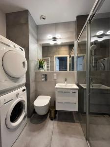 Un baño con lavadora y lavabo. en Apartament Starowiejska 54, en Gdansk