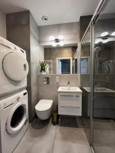 a bathroom with a washing machine and a sink at Apartament Starowiejska 54 in Gdańsk