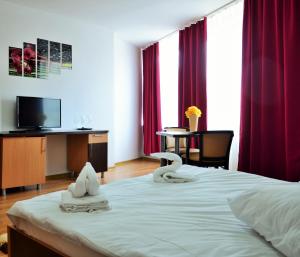 Una habitación de hotel con una cama con toallas. en ApartHotel Zorilor, en Cluj-Napoca