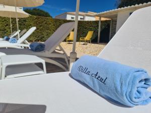 - une serviette bleue assise sur une chaise de plage blanche dans l'établissement Villa Azul - Clever Details, Luxury villa, private pool, access to a club with tennis court, playground, communal pools, à Vilamoura