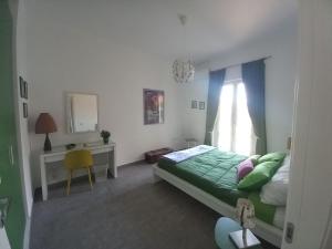- une chambre avec un lit, un bureau et une fenêtre dans l'établissement Lo scorcio della Neapolis Accogliente appartamento pressi parco Neapolis, à Syracuse