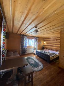 Habitación grande con 2 camas y techo de madera. en Сімейний номер 2 Садиба У Ані en Synevyrsʼka Polyana