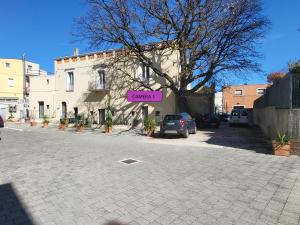 un estacionamiento con una señal rosa delante de un edificio en Le Dimore nel Cortile con patio e parcheggio privato en Matera