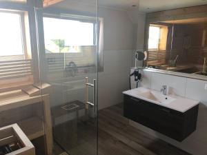 a bathroom with a sink and a glass shower at Villa Major in Göhren-Lebbin +20 photos