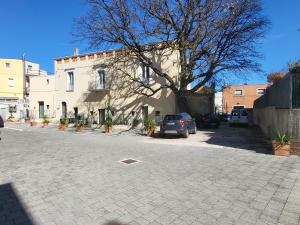 un edificio con coches estacionados en un estacionamiento en Le Dimore nel Cortile con patio e parcheggio privato en Matera