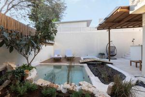 a backyard with a swimming pool and a house at Sera Suites in Merhavyāh
