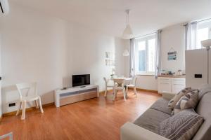 ein weißes Wohnzimmer mit einem Sofa und einem Tisch in der Unterkunft MAZZINI 12- Appartamento centrale con posto auto privato-wifi-aria condizionata in Rapallo