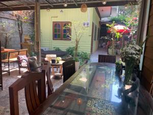 un patio con tavolo in vetro e sedie di Retro At Phra Sing Guest House a Chiang Mai
