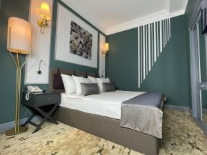 a bedroom with a large bed with green walls at Teatro Rooms Hotel in Baku