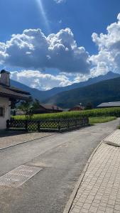 an empty road with a fence in front of a vineyard at Casa dei sogni in Valdaora