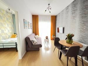 Una sala de estar con una mesa y un dormitorio. en Apartament Starowiejska 54, en Gdansk
