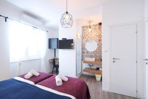 a bedroom with a large bed with a purple blanket at Zaratino rooms in Zadar