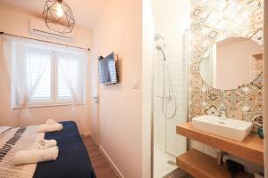 a bathroom with a shower and a sink and a mirror at Zaratino rooms in Zadar