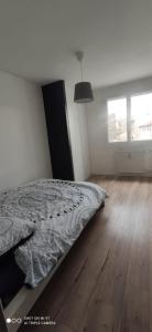 1 dormitorio con 1 cama y suelo de madera en Appartement 4 personnes, garage privé, balcon en Saint-Étienne