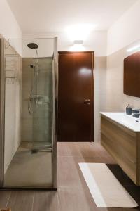 uma casa de banho com um chuveiro e uma porta de vidro em Bella Camelia - Lago di Como em San Siro
