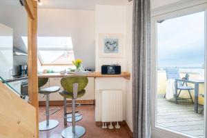 una pequeña cocina con mesa, sillas y ventana en Strandpark-Grossenbrode-Haus-Meerblick-Wohnung-16, en Großenbrode
