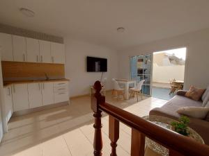 uma cozinha e sala de estar com um sofá e uma mesa em We Fuerteventura em Caleta de Fuste