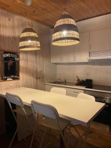 a kitchen with a table and chairs and two lights at Douro in Melres