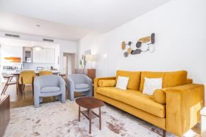un salon avec un canapé jaune et une cuisine dans l'établissement Apartamento Casa Branca 360, à Funchal