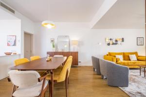 - une salle à manger avec une table, des chaises et un canapé dans l'établissement Apartamento Casa Branca 360, à Funchal