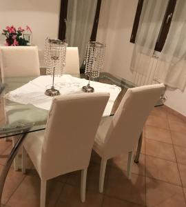ポルト・トッレスにあるAppartamento Margóのガラステーブル(白い椅子付)、ワイングラス