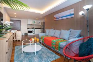 un soggiorno con un divano e un tavolo di The Title Rawai West Wing Pool View Suite a Rawai Beach