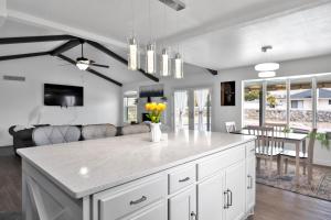 a kitchen with a white island with yellow flowers in a vase at Home with Mountain View/Pool/Tub in El Paso