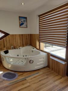 a bath tub in a room with a window at Къща за гости Бялото Конче in Beli Iskar