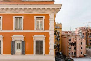 een oranje gebouw met witte ramen en gebouwen bij 41 NAZIONALE SUITE 41 in Rome