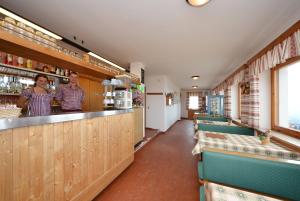 Ein Mann und eine Frau stehen in einer Bar in einem Restaurant in der Unterkunft Rifugio Fronza alle Coronelle - Kölner Hütte in Welschnofen