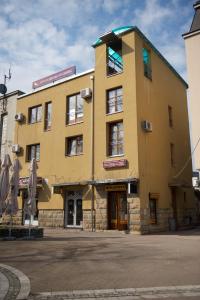 a large yellow building with a building at Apartments Passage in Vrnjačka Banja