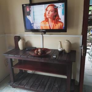 uma televisão em cima de uma mesa de madeira com uma mesa em Fishermen s Cave em Port St Johns