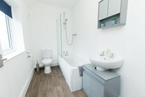 Baño blanco con lavabo y aseo en K Suites - Ely Road en Arksey