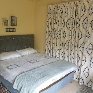 uma cama num quarto com uma cortina e uma cama sidx sidx em Fishermen s Cave em Port St Johns