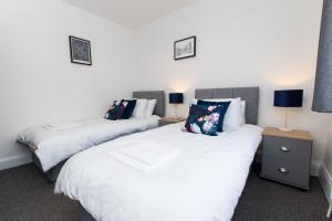 two beds sitting next to each other in a bedroom at K Suites - Ely Road in Arksey