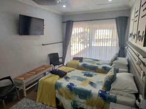 1 dormitorio con 2 camas y TV de pantalla plana en Rest4Sure, en Ashton