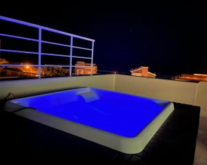 a blue bath tub sitting on top of a roof at night at Cobertura Jacuzzi Vista Mar in Bombinhas