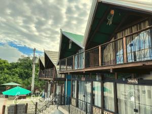 a building with a balcony and a table and umbrella at Encanto Chalés – 150m da Praia Grande – Penha – SC in Penha