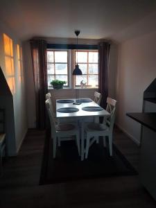 a dining room with a table and chairs and a window at Lilla lägenheten in Broddetorp