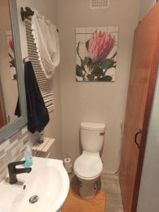 Łazienka z białą toaletą i umywalką w obiekcie Rest4Sure w mieście Ashton
