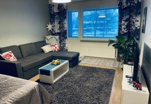 a living room with a couch and a tv at Saimaa Harbour apartment - AC, WiFi, Balcony & City Centre in Lappeenranta