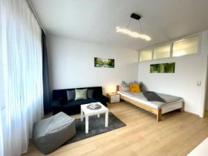 een slaapkamer met een bed, een bank en een tafel bij **Modernes Apartment in zentraler Lage** in Graz