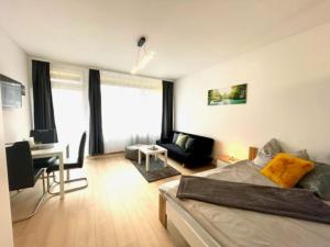 uma sala de estar com uma cama e uma secretária em **Modernes Apartment in zentraler Lage** em Graz