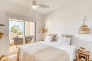 a white bedroom with a bed and a balcony at Hanami Puerto Alto PA 3-12 in Estepona +22 photos