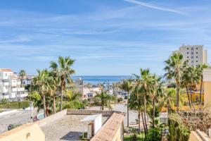 a view of a city with palm trees and the ocean at Hanami Puerto Alto PA 3-12 in Estepona