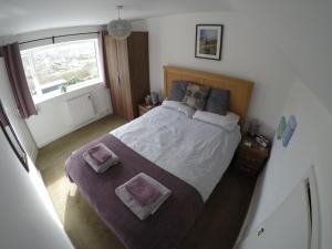 a bedroom with a large bed with two towels on it at Bodeinion in Nefyn