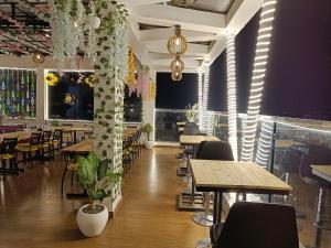 een restaurant met houten tafels, stoelen en planten bij Hotel Imperial Crown in Rewāri