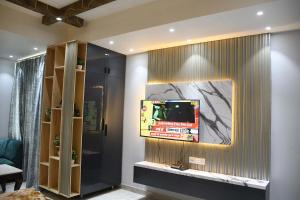 een woonkamer met een tv aan de muur bij Hotel Imperial Crown in Rewāri