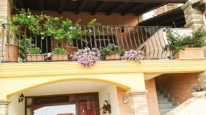 un balcone con piante in vaso in cima a un edificio di La Terrazza Fiorita a Nebida